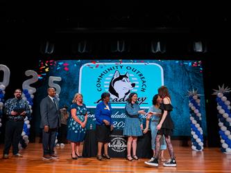 student shaking admin hands on stage