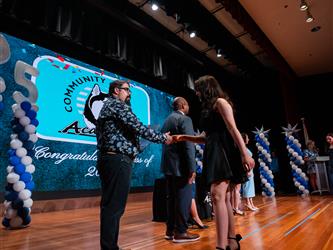 student shaking admin hands on stage