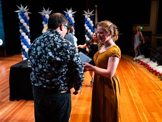 student receiving certificate on stage