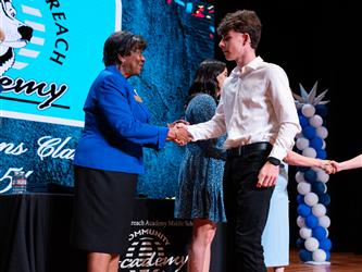 student shaking admins hands on stage