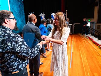 student shaking admin hands on stage