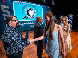 student shaking admin hands on stage
