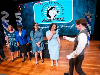 student shaking admin hands on stage