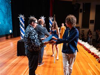 student receiving certificate on stage