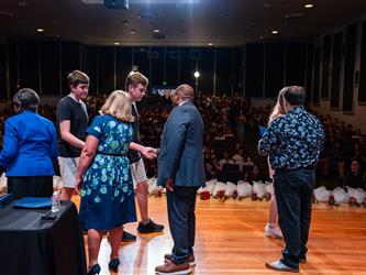 student shaking admins hands on stage