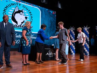 student shaking admins hands on stage