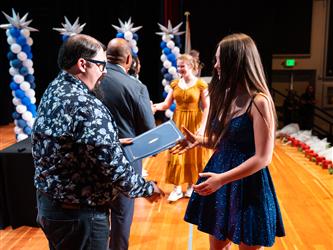 student receiving certificate on stage