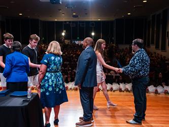 student shaking admins hands on stage