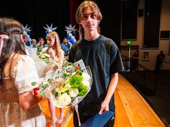 student presenting flowers