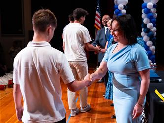 student shaking admins hands on stage