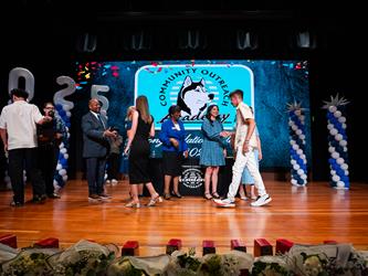 student shaking admin hands on stage