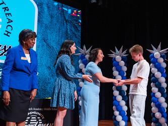 student shaking admins hands on stage