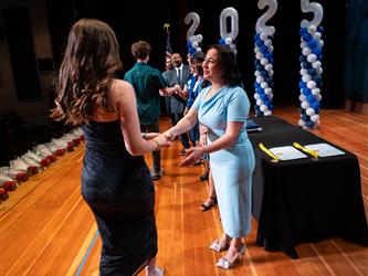 student shaking admin hands on stage