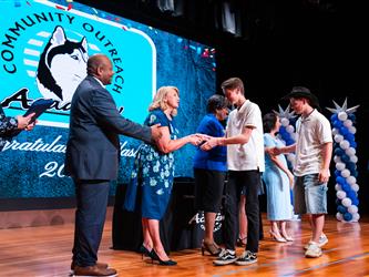 student shaking admins hands on stage