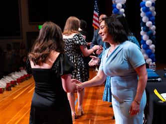 student shaking admins hands on stage
