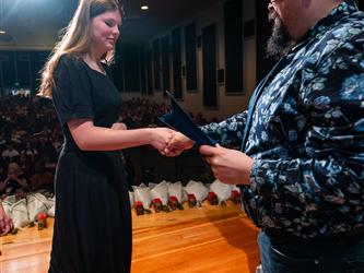 student shaking principals hand on stage