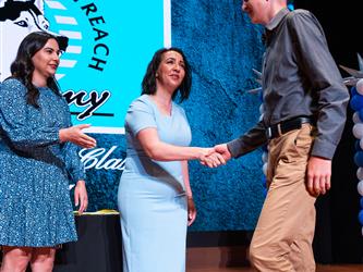 student shaking admins hands on stage