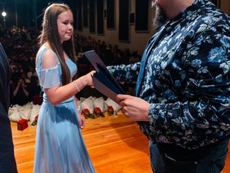 student shaking principals hand on stage