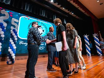 student shaking principals hand on stage