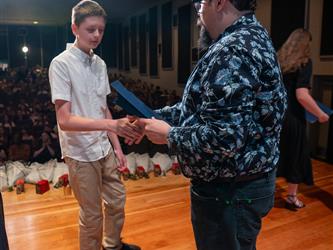 student shaking principals hand on stage