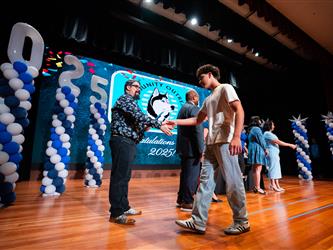 student shaking admin hands on stage