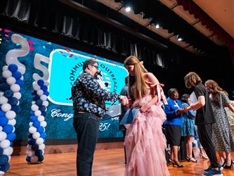 student shaking admin hands on stage
