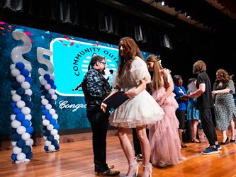 student shaking admin hands on stage