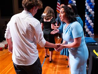 student shaking admins hands on stage