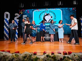 student shaking admin hands on stage