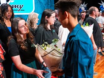 student shaking admin hands on stage