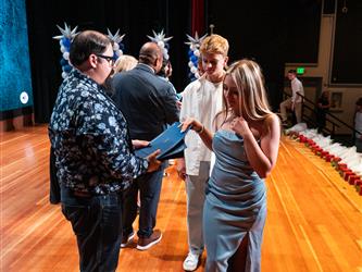student shaking admin hands on stage