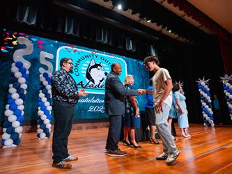 student shaking admin hands on stage