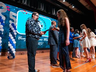 student shaking admin hands on stage
