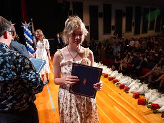 student shaking admin hands on stage