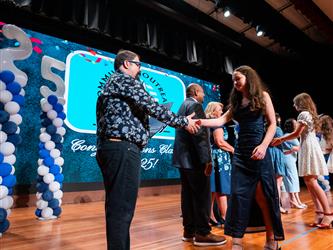 student shaking admin hands on stage