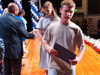 student receiving certificate on stage