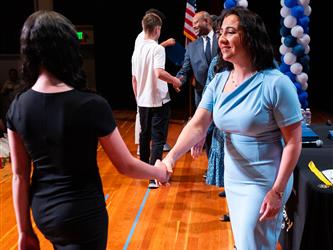 student shaking admins hands on stage