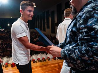 student shaking principals hand on stage