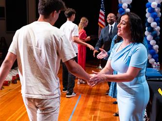 student shaking admins hands on stage